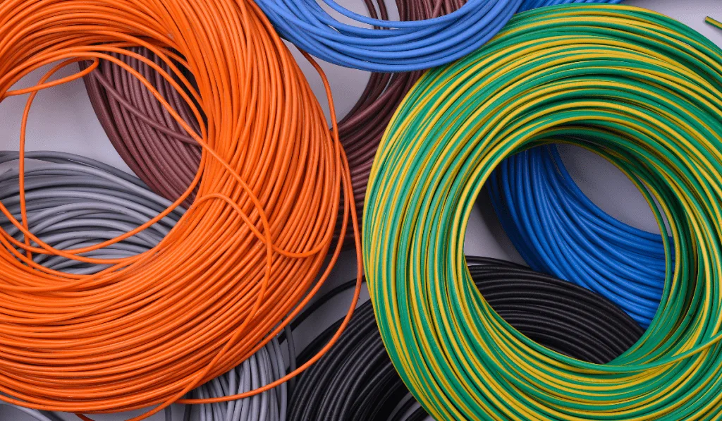 A bunch of rolled colorful wires on the floor.