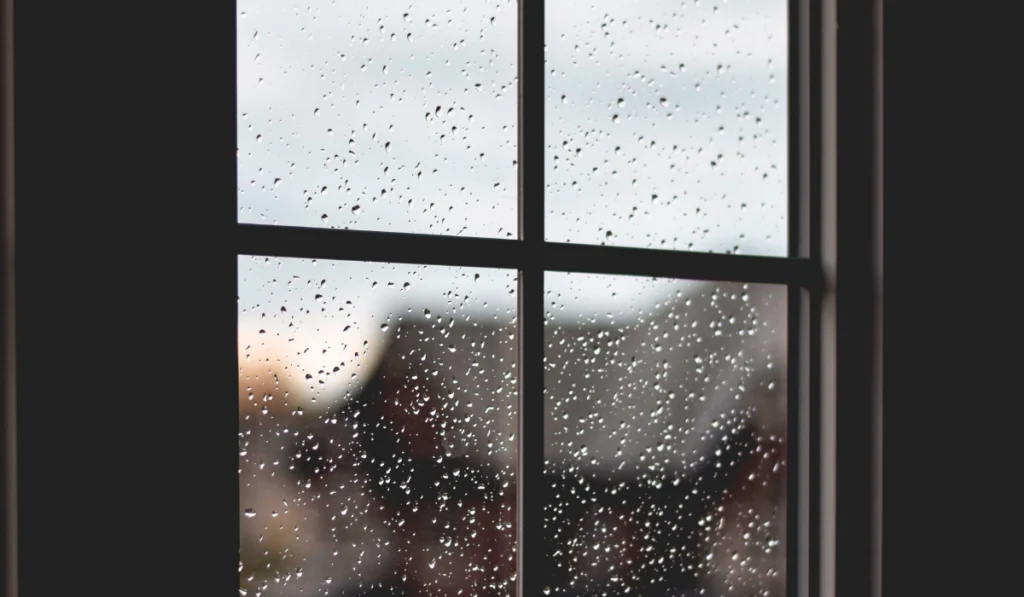 Dark window frame with rain water drops