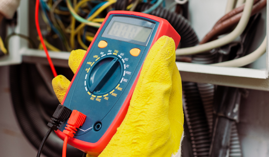 Panoramic crop of electrician using multimeter near electrical distribution box