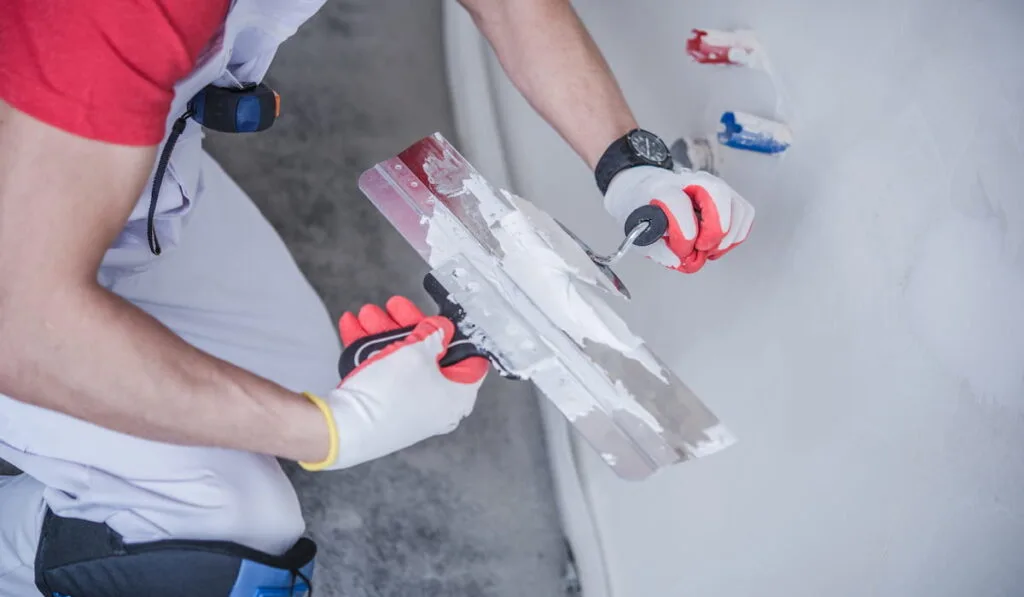 Worker with Patching drywall Material and Tools