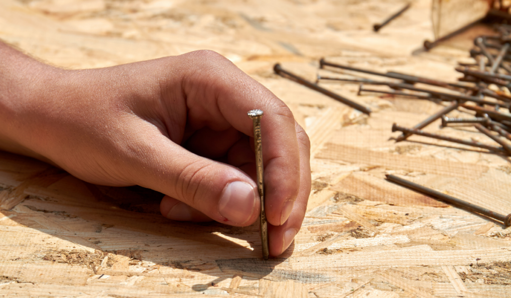 Young hand holding the nail