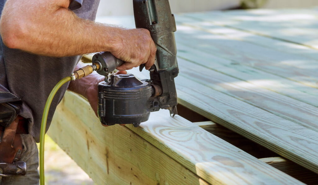 man installing wood on deck patio