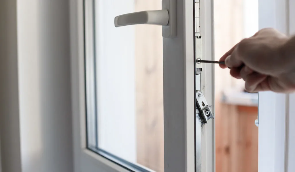 man using screwdriver to tweak the Door Hinge Pin