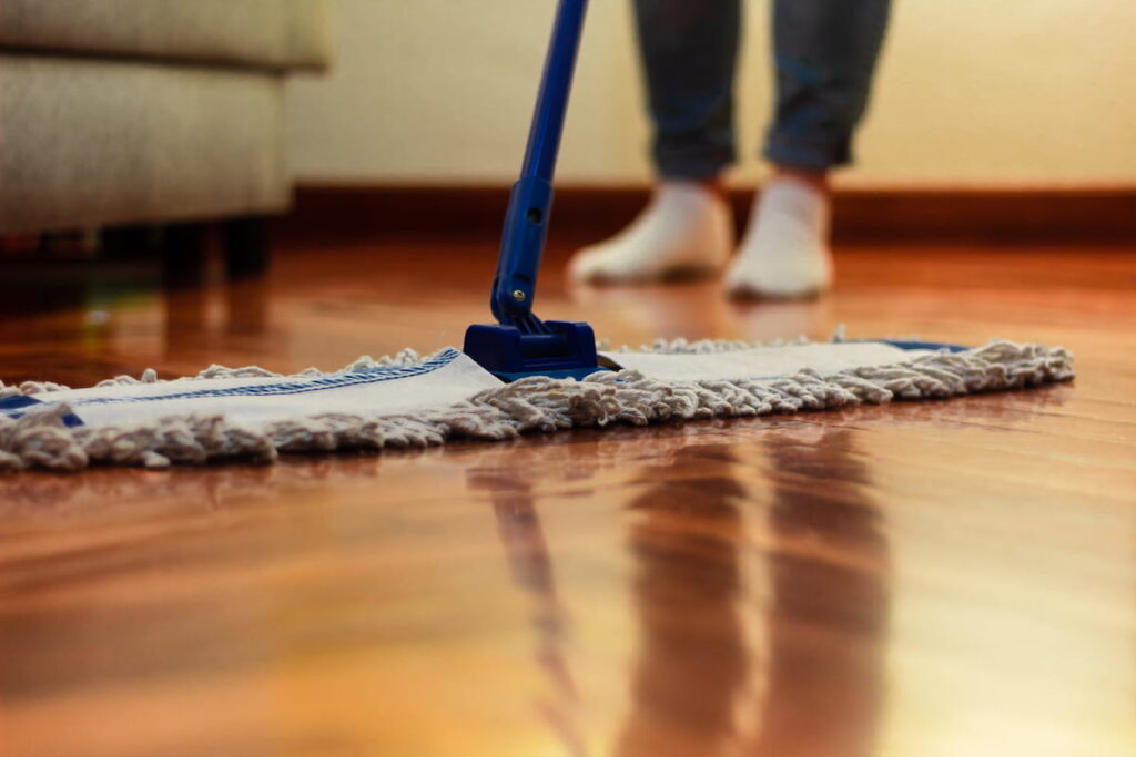 person cleaning the hardwood floor 