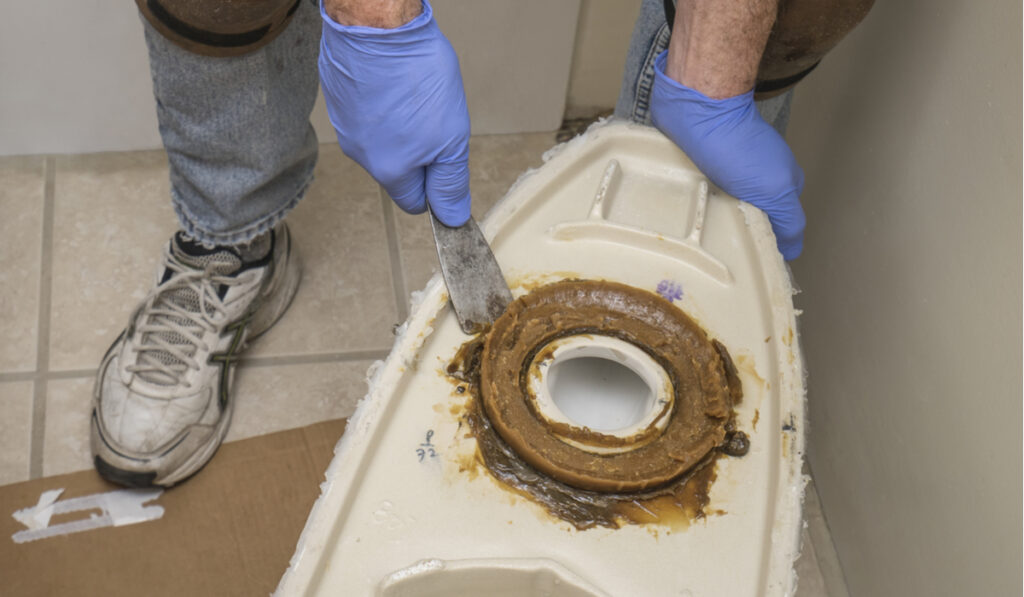 plumber changing toilet wax ring 