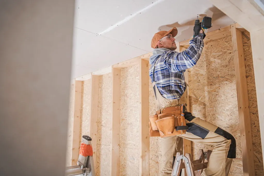 worker attaching drywall