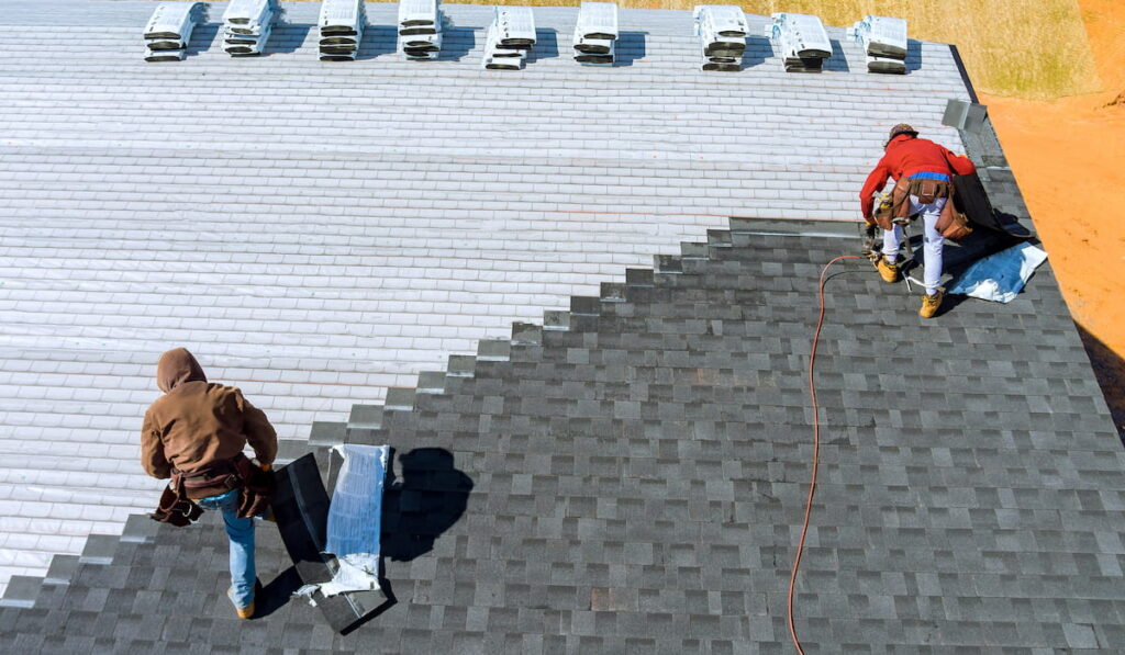 workers installing bitumen roof shingles