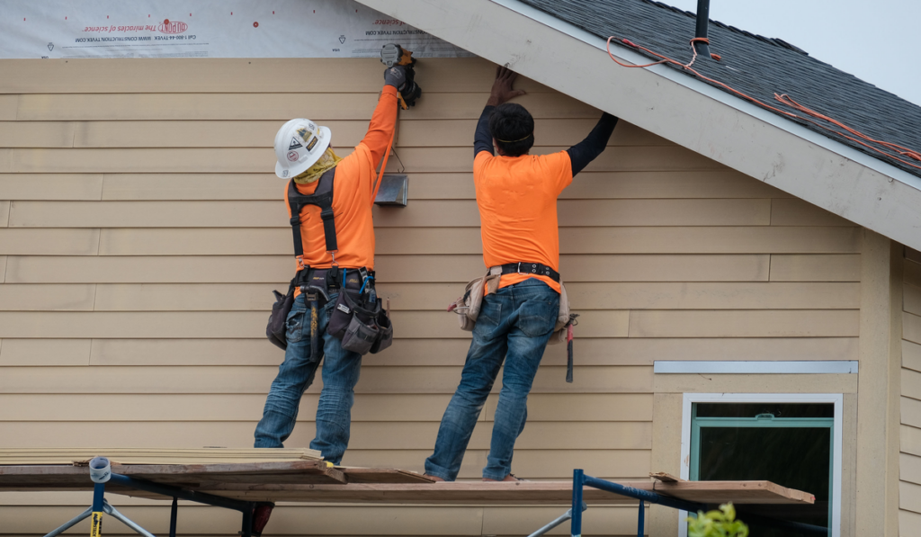 workers installing vinyl siding facade