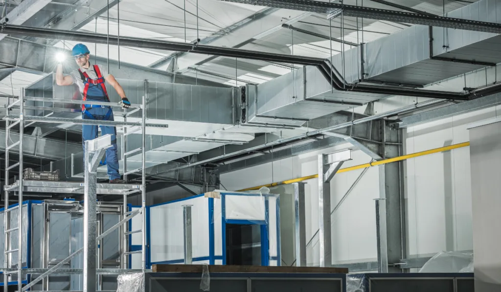 Professional HVAC Technician with Flashlight Overlooking Finished Air Ventilation System