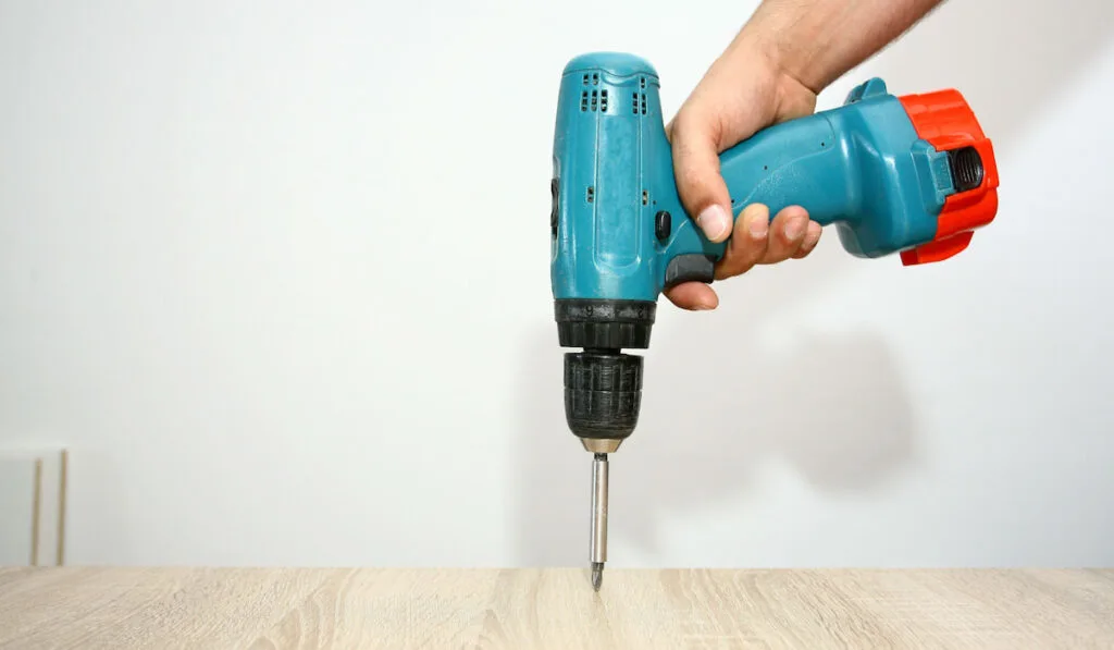 closeup photo of a hand drilling floor 