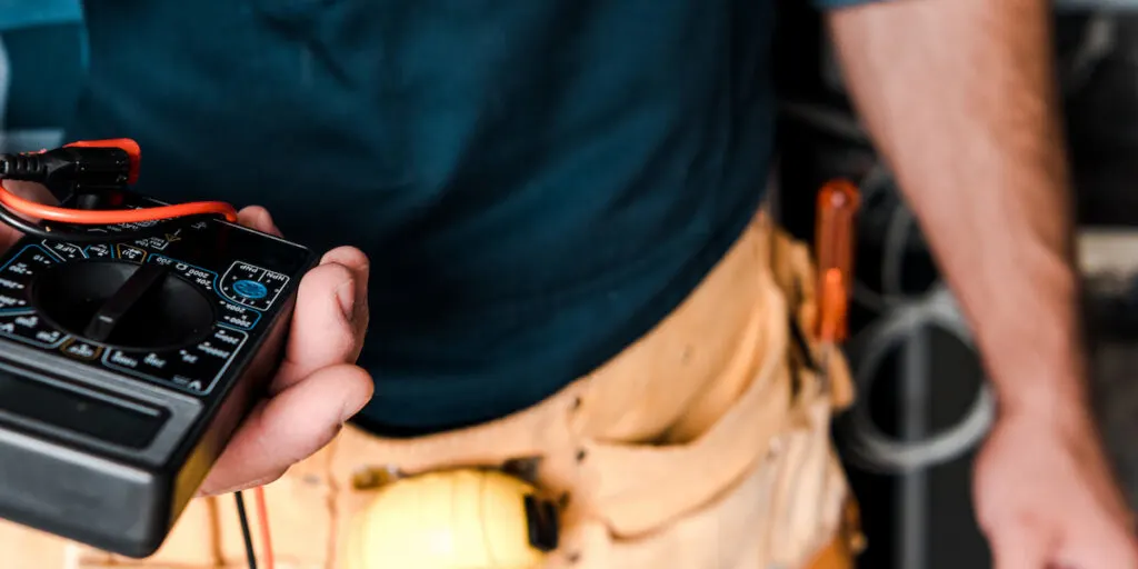  technician holding digital meter