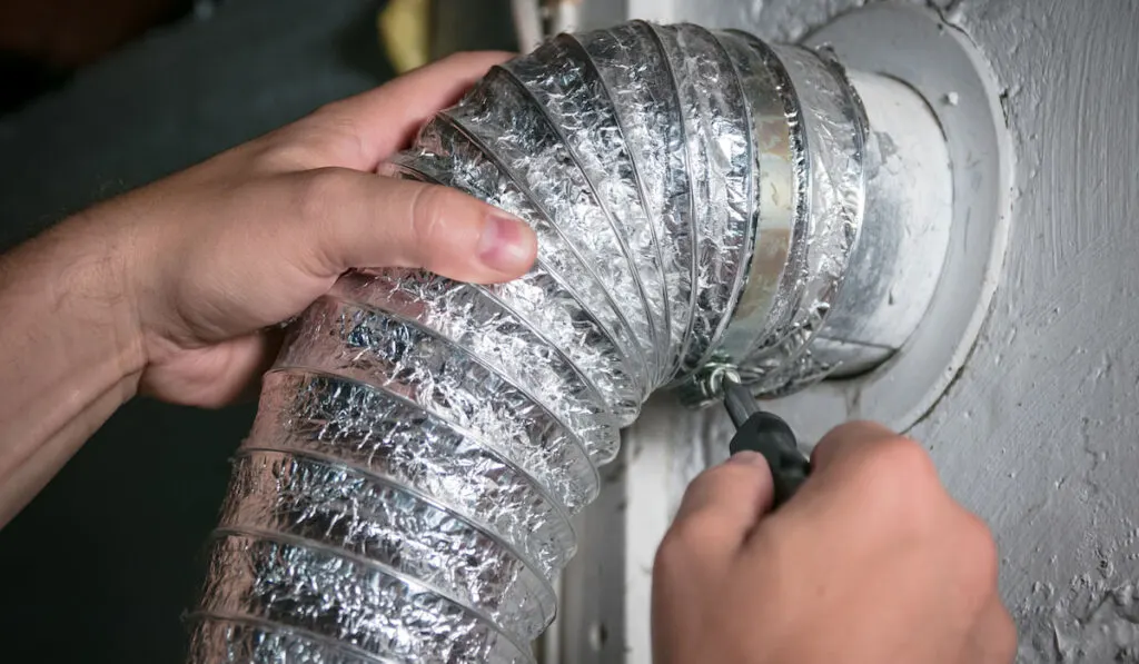 Flexible  Aluminum dryer vent hose, attaching/detaching from wall vent by turning screw in steel duct clamp.