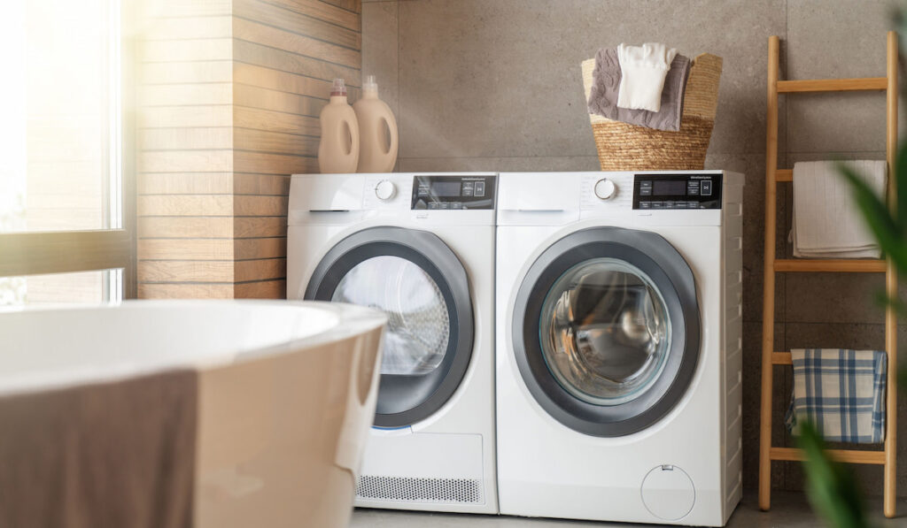 Interior of a real laundry room with a washing machine  and dryer at home