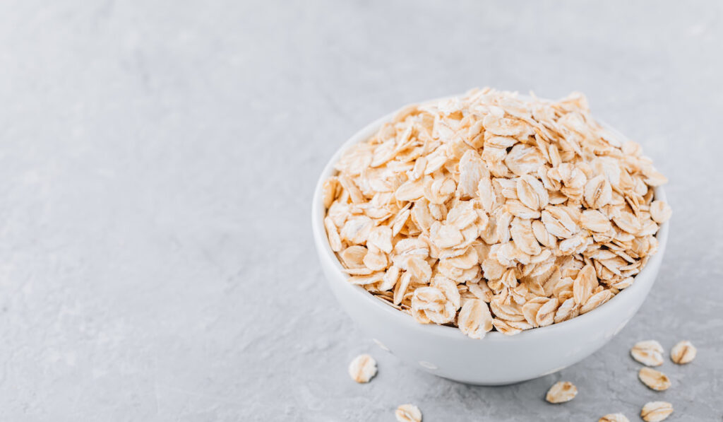 Bowl with raw oatmeal (oat flakes)
