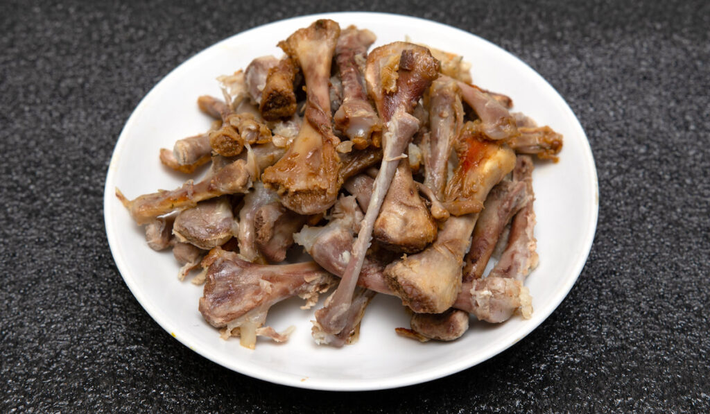 Chicken bones on a plate, after eating.
