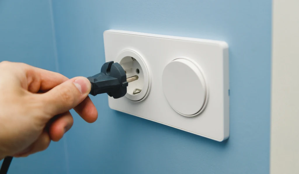Inserting power cord receptacle in wall outlet
