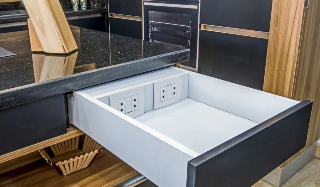 Interior design decor showing modern kitchen with sliding drawer and electric sockets