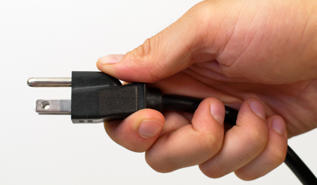 North American electrical cord held in a man's hand