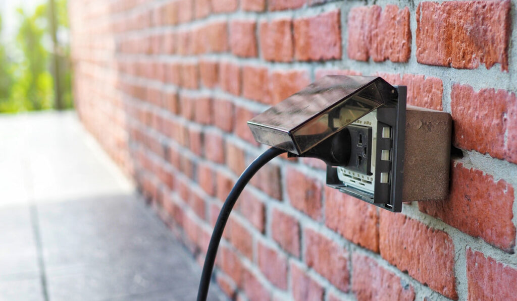 Outdoor Electrical Outlet with cover on brick wall