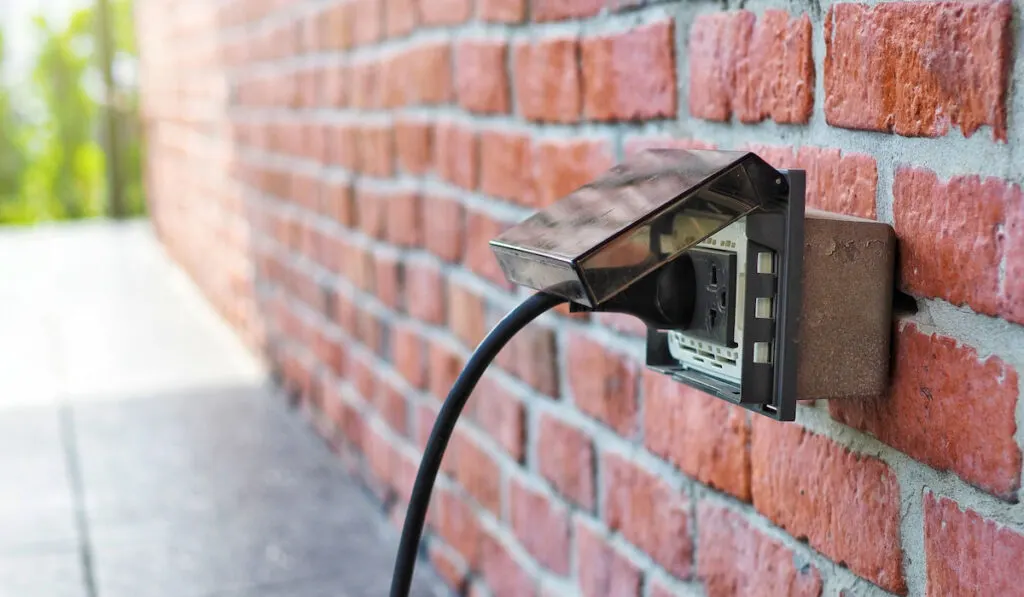 Outdoor Electrical Outlet with cover on brick wall