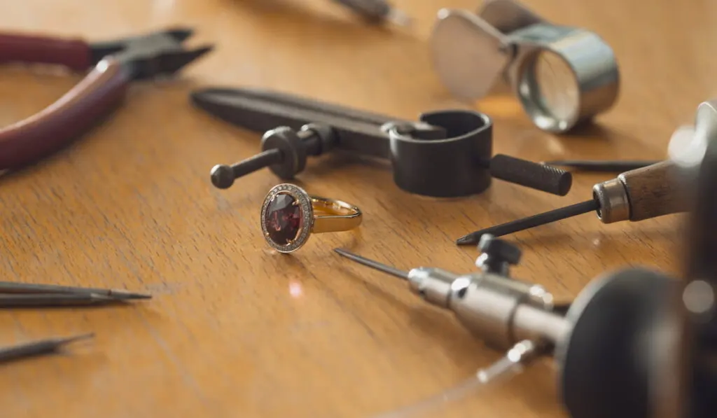 Tools and equipment for jewelry work on an antique wooden desktop