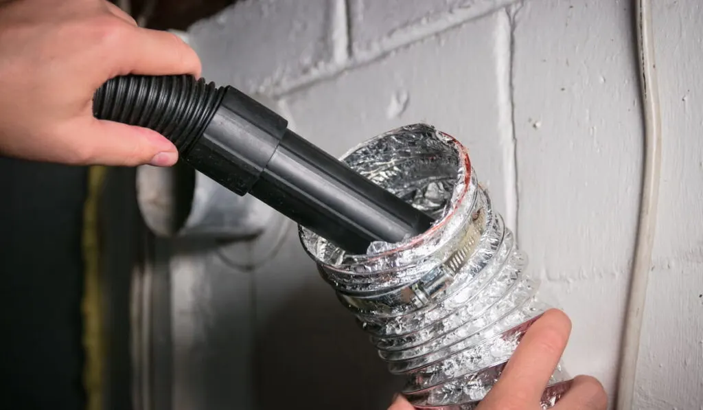 Vacuum cleaning a flexible aluminum dryer vent hose, to remove lint and prevent fire hazard