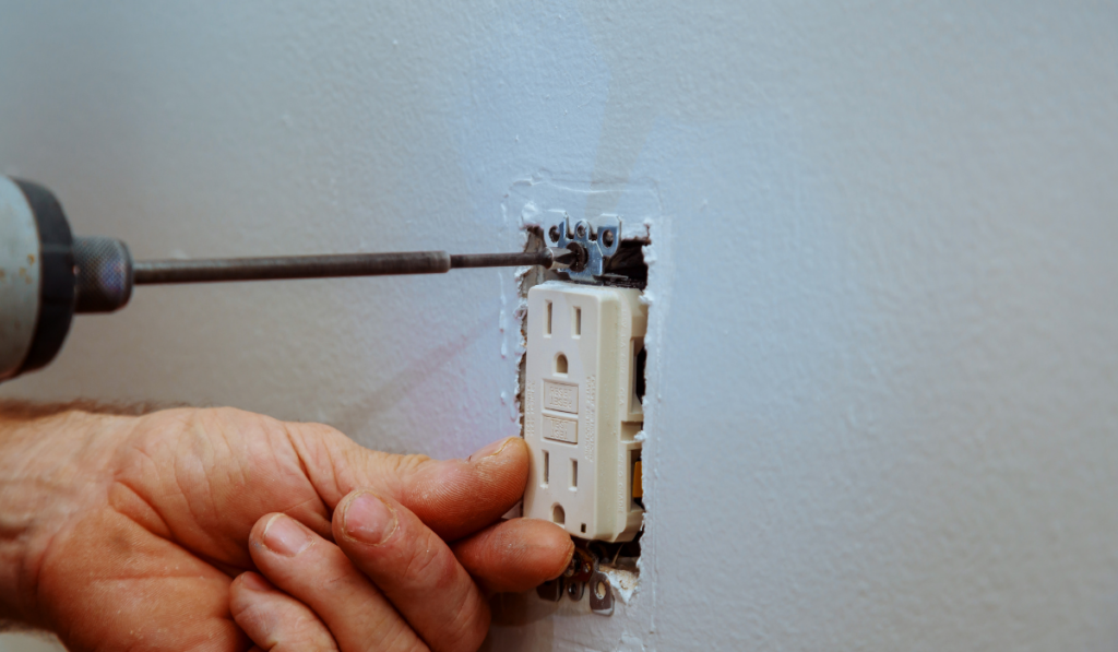 Wall socket installation a screw on an electrical outlet