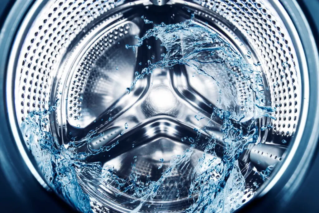 Water splashes in washing machine drum, close up