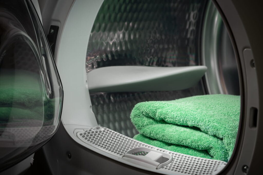 electric dryer with a green towel inside 