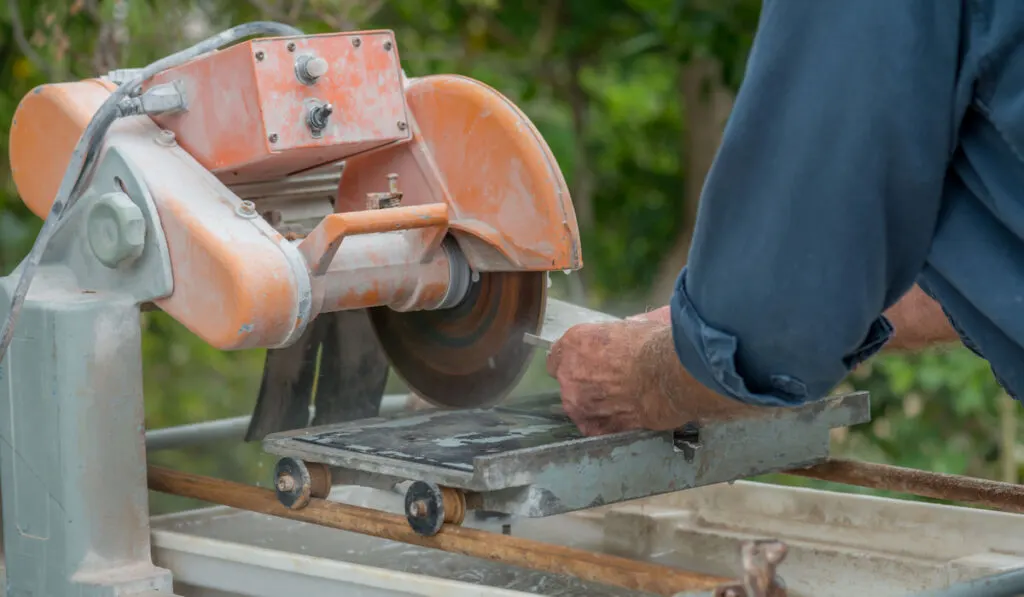 Professional worker cutting tiles using a tile saw