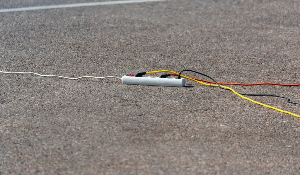 Electric extension cord with wires on the road