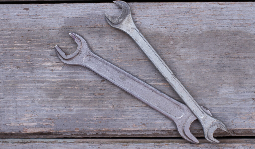 open-ended wrenches on old wooden boards background