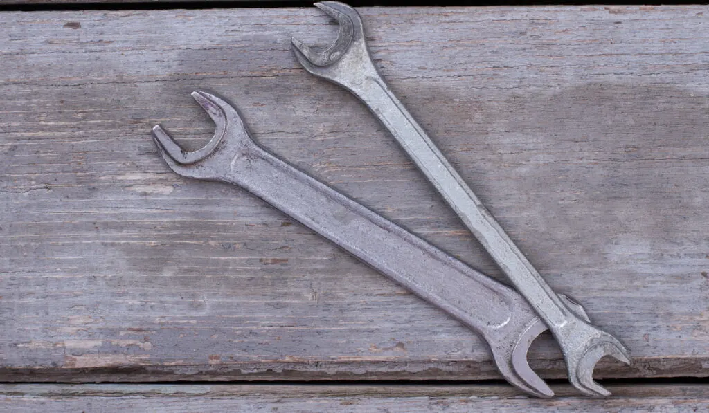 open-ended wrenches on old wooden boards background