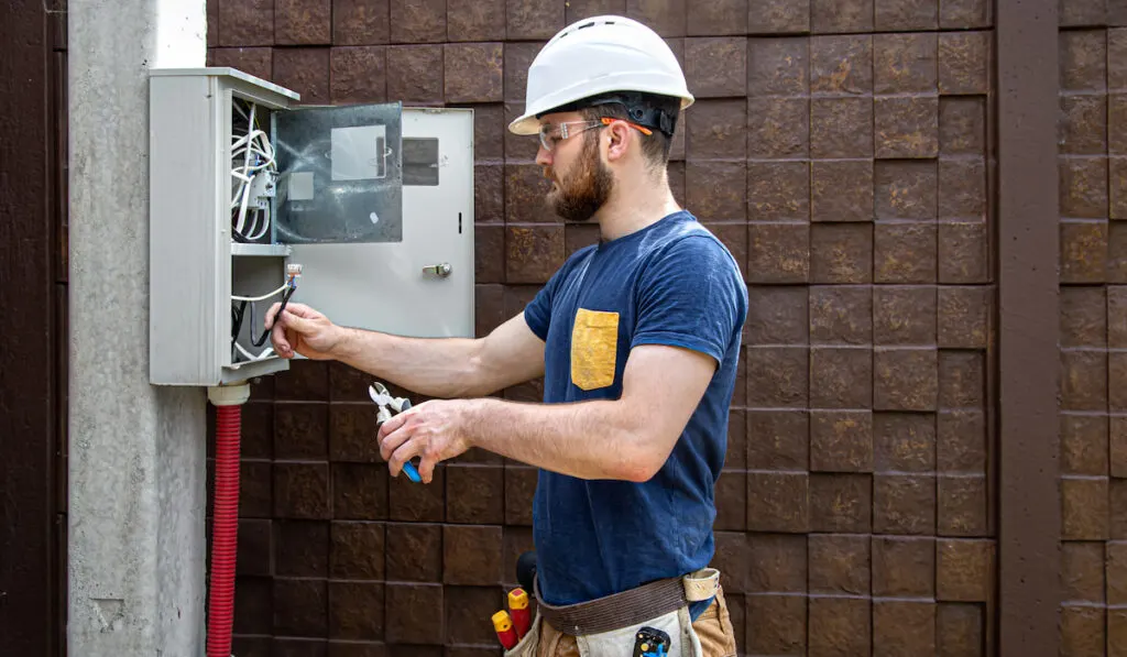 professional electrician examines cable connection in the electrical line 