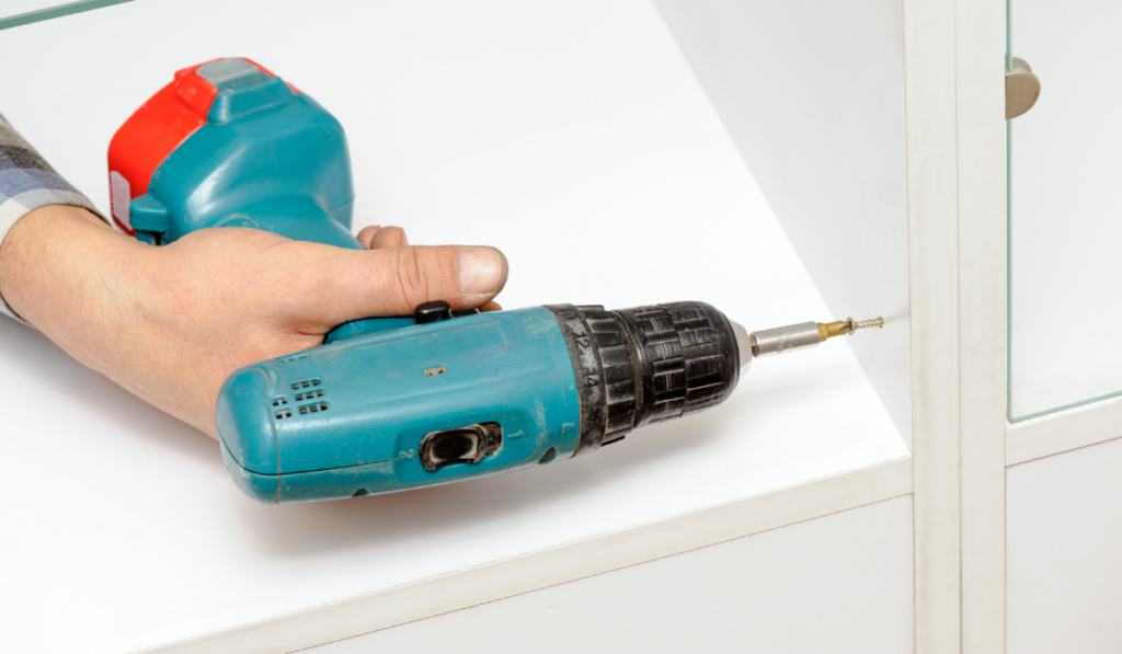 Worker using the electric screwdriver
