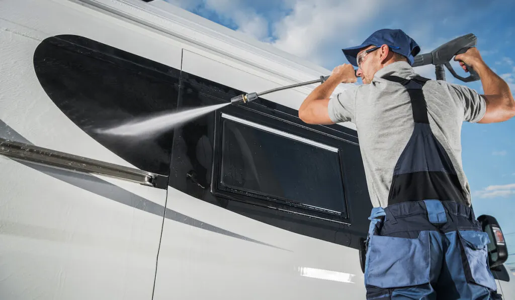 Car Detailer pressure washing modern camper van