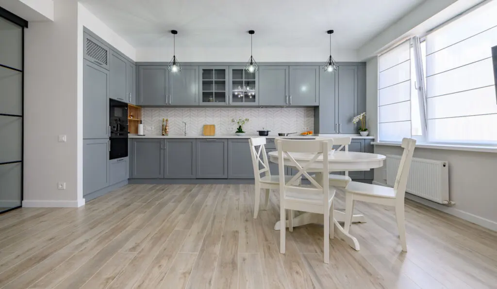 Trendy grey and white modern kitchen interior with white dining table 