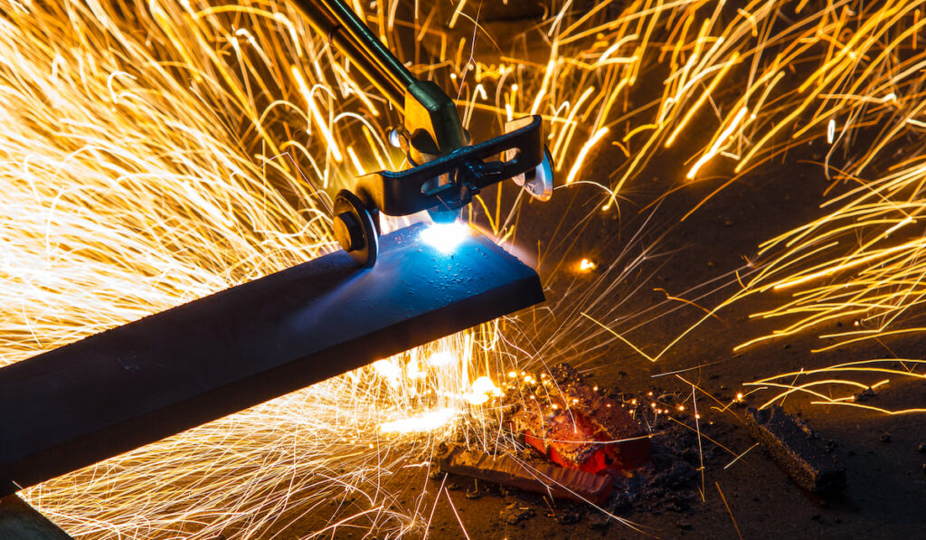 Worker cutting metal using acetylene torch