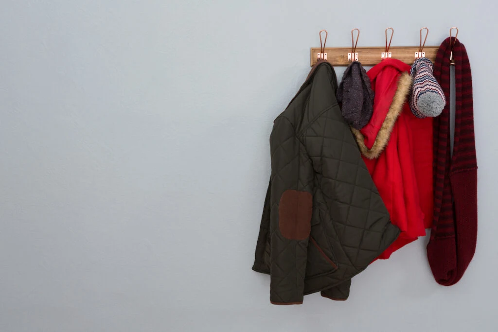 cold weather clothing hanging on a adhesive hook on the wall