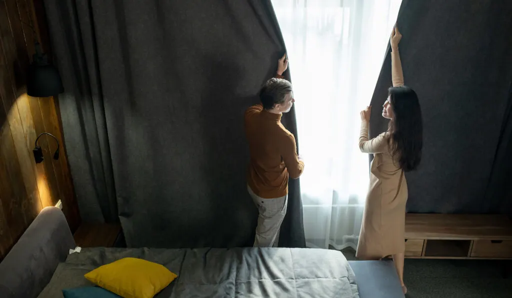 couple closing the curtain in their room