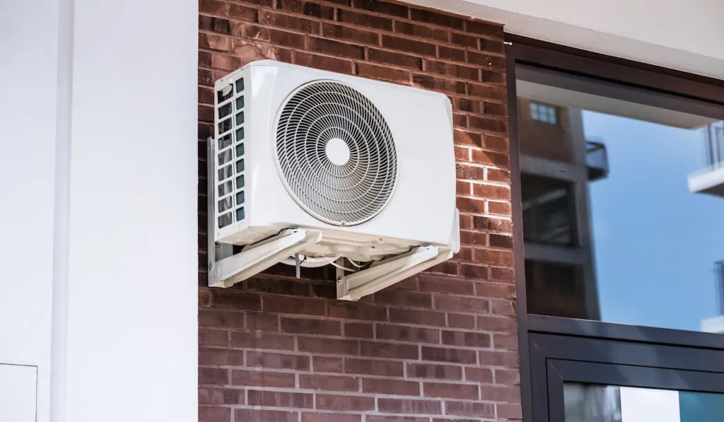 Air Conditioner And Heat Pump. Split HVAC System Unit installed on the side wall of a house