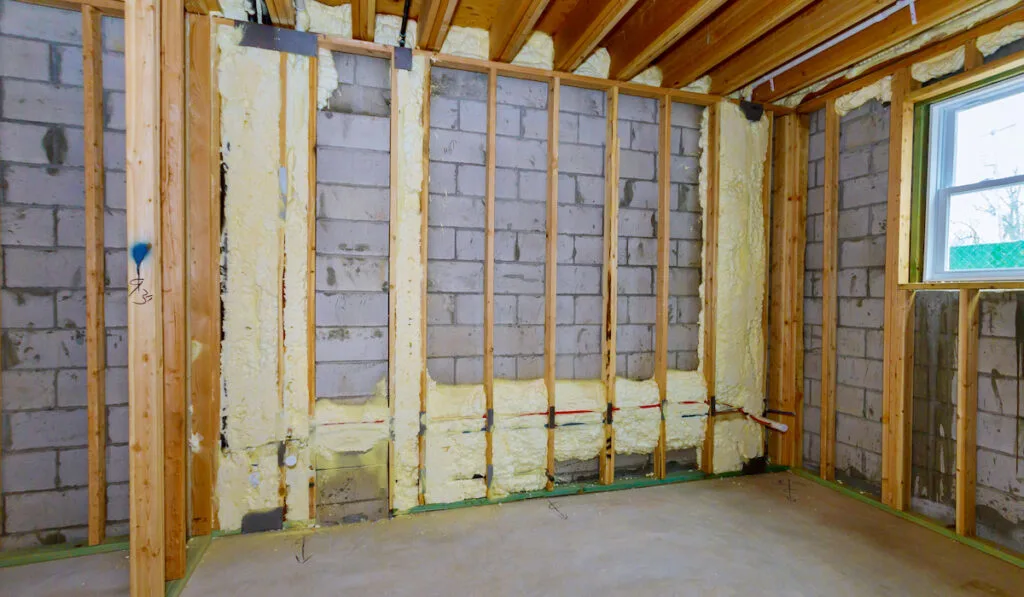 New wooden house in foam for insulation the wall of a basement unfinished under construction