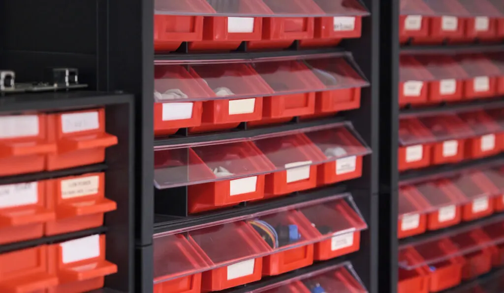 Screws, bolts, nuts, in red storage boxes in a workshop